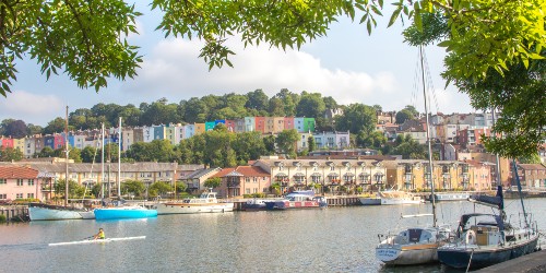 colourful houses with a river infront and a boat
